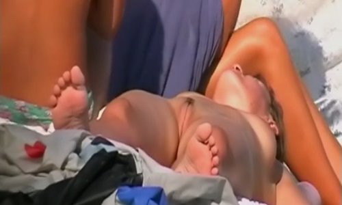 На русском пляже нудистка светит красивой киской.